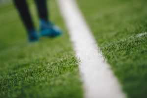 Blurred Feet of Footballer Walking on Pitch