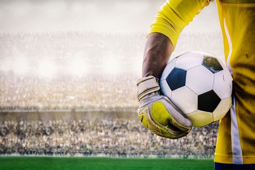 Goalkeeper in Yellow Holding Football