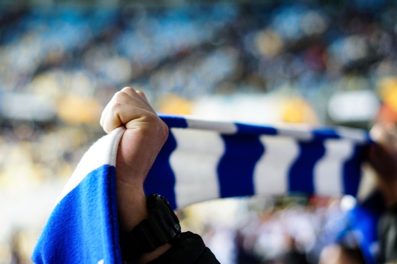Football Fan Holding Blue and White Scarf