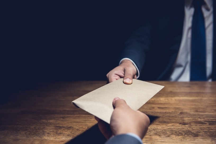 Envelope Passed Across Desk in Dark Room
