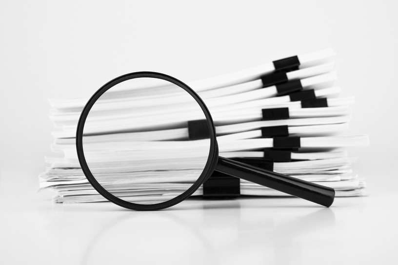 Stack of Reports with Magnifying Glass