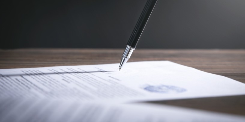 Pen Signing Contract with Blue Stamp