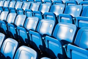 Empty Blue Stadium Seats Against Bright Light