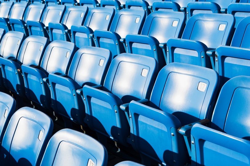 Empty Blue Stadium Seats Against Bright Light